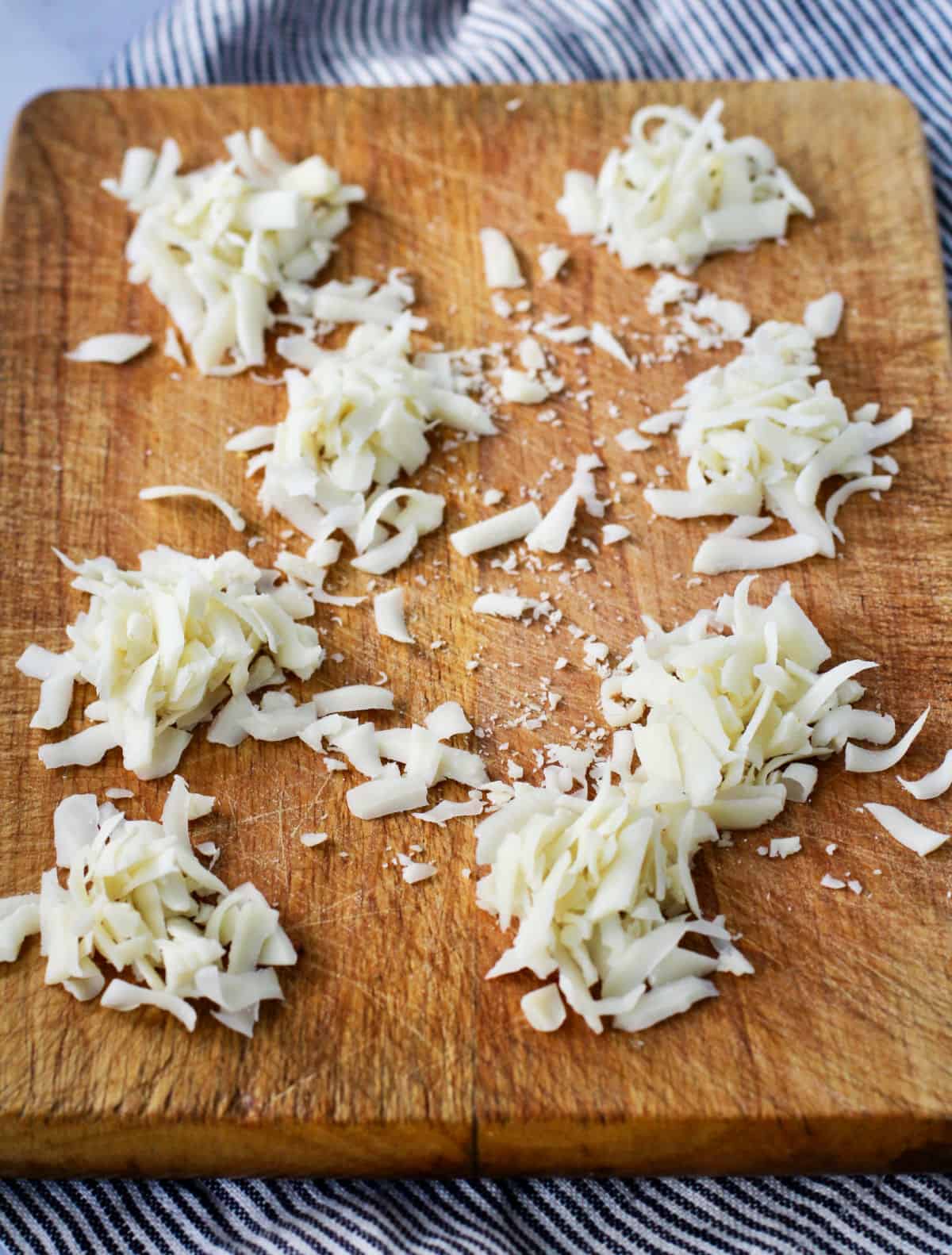 Piles of asiago cheese that has been grated.