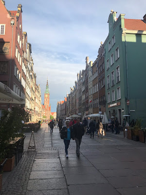 dluga street in gdansk, pastel buildings under a blue sky