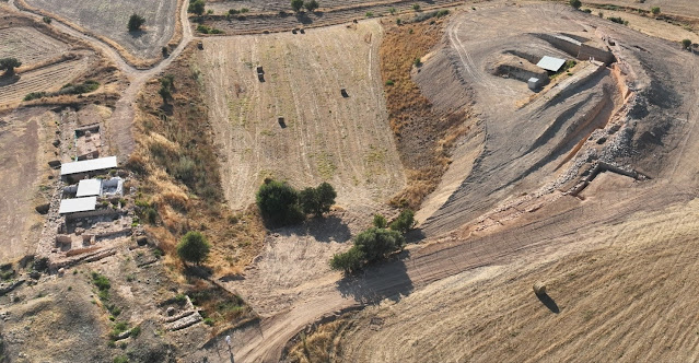 Εικ. 12. Λαόνα: διακρίνεται το τείχος (δεξιά/βόρια). Χατζηαπτουλλάς (αριστερά/νότια): διακρίνεται το ανάκτορο και το εργαστηριακό σύμπλεγμα με προσωρινές οροφές προστασίας. Φωτογραφία από UAV (drone) από ανατολικά προς δυτικά.