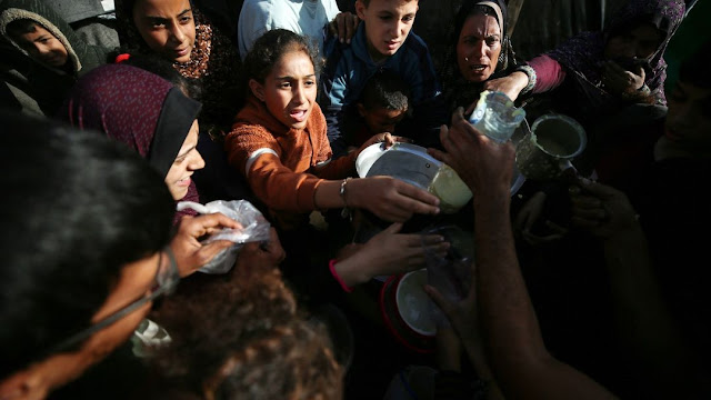 Palestinian children getting food at the refugee camps in Gaza  by Madji Fathi