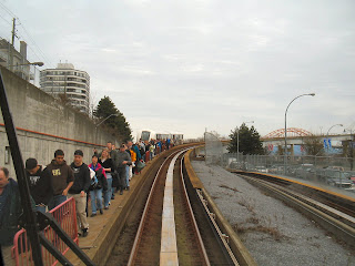 Skytrain passengers walk beside tracks to Columbia Station