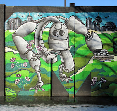 Mural of a large friendly-looking robot picking flowers