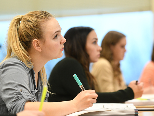 Students take notes while looking ahead.