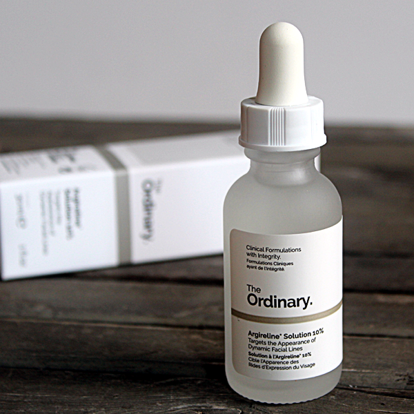 Bottle of The Ordinary's Argireline 10% Solution sitting on a wooden table with the product box in the background