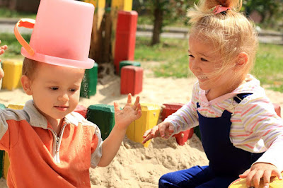 Boys-Little-girls-playing-with-Bucket-wearing-on-his-head