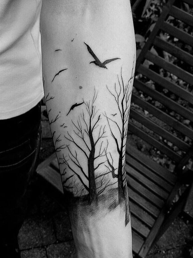 Tatuaje de un árbol rodeado por el sol y la luna en el antebrazo