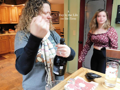 woman opening prosecco with teen watching