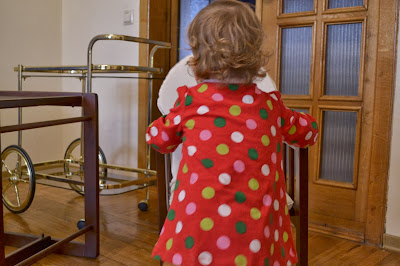 a small girl is playing with the chair in the living-room