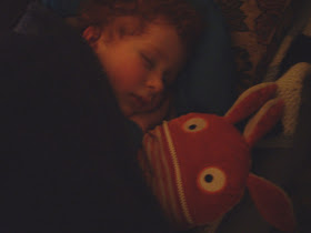 Child sleeping peacefully with Sorgenfresser Worry-Eater soft doll