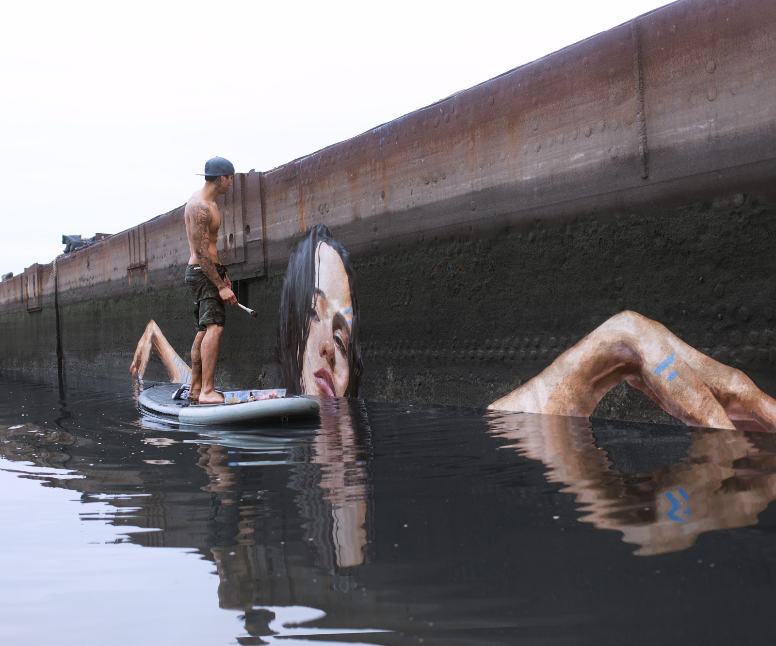 Artist Paints Murals of Women While Floating on a Surfboard