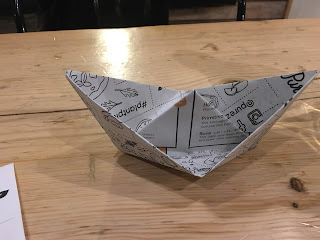 old menu folded up as a paper hat or boat