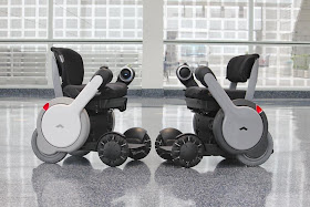 picture of 2 whill wheelchairs that are white grey and black and smaller than typical wheelchairs. They have different hand rests that come down and up 