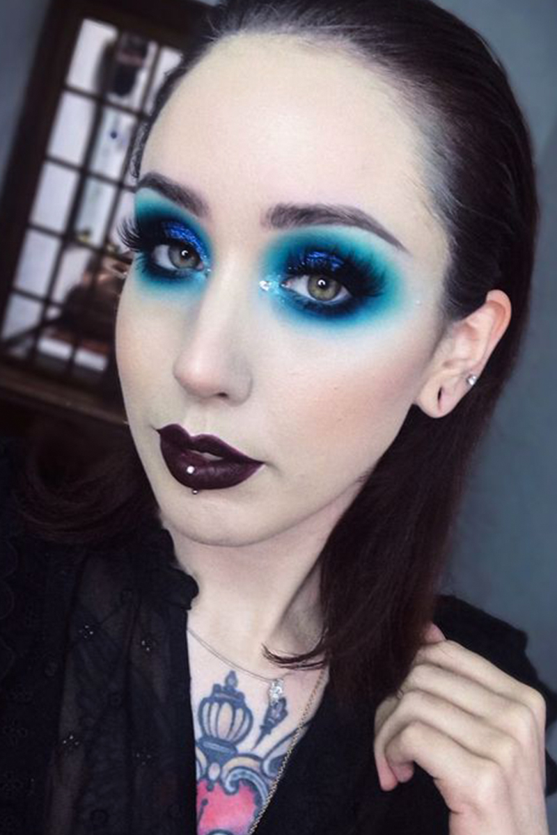 close-up portrait of a beautiful young woman with a pretty blue goth makeup look