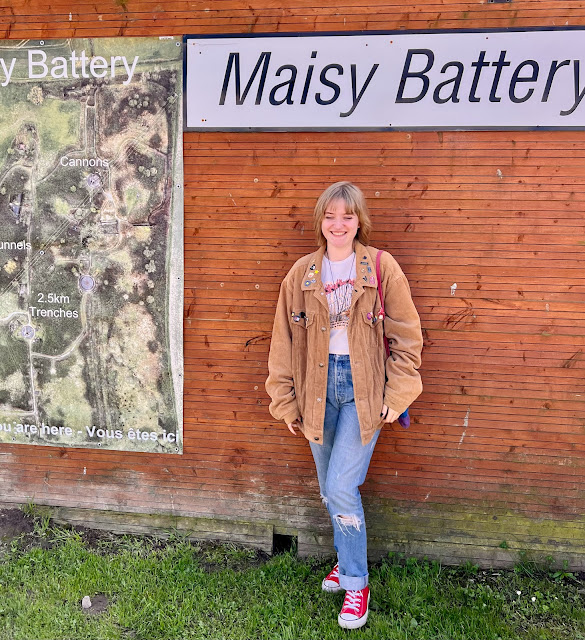 madmumof7's daughter next to sign reading Maisy Battery