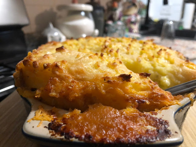 Baked cottage pie in serving dish on stovetop