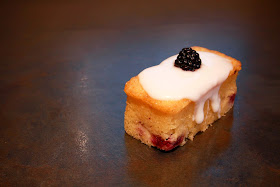 Blackberry and yoghurt mini loaf cake topped with lemon icing and a blackberry