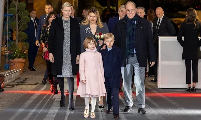 Princess Charlene wore a rhinestone tweed top and skirt by Louis Vuitton. Princess Gabriella wore a pink coat by Emporio Armani