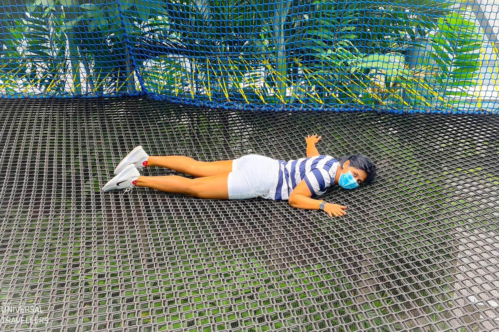 A girl is lying on the Manulife Sky Nets, located at level 5 inside the Jewel Changi Airport