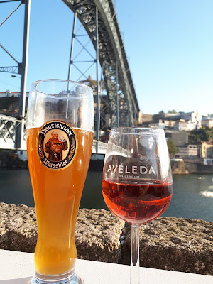 Een biertje en een rosé met op de achtergrond een brug in Porto