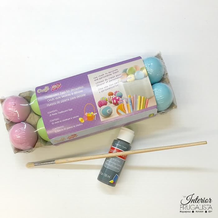 An upcycled Easter centerpiece box with faux wheatgrass, chair spindle carrots, and DIY speckled eggs for a fun budget Easter table decoration idea.