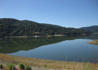 Hills reflected in the calm water of Lexington Reservoir, view from the dam, Los Gatos, California