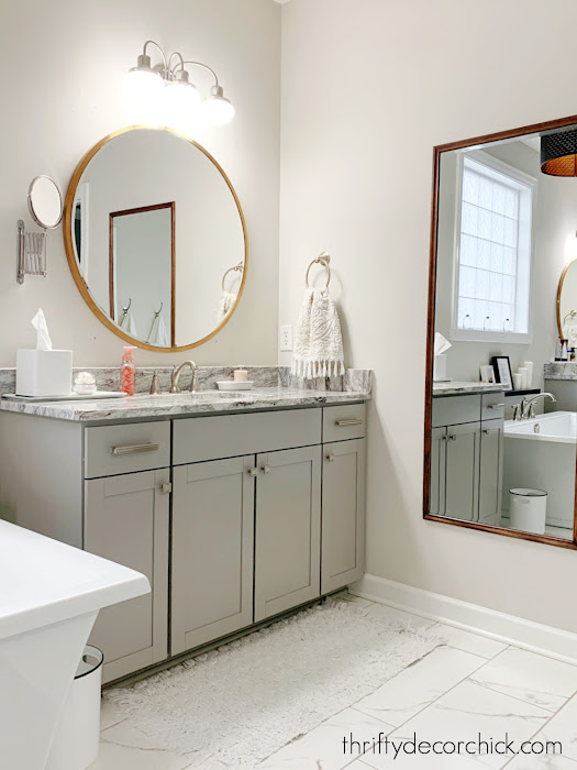 round brass mirror above vanity