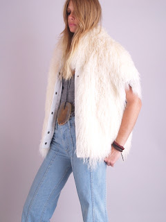 Vintage 1970's fluffy white Mongolian lamb fur vest with snap front closure and pockets.