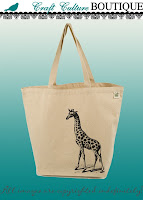 Cream-color canvas tote with long handles. Standing in the lower right corner and stretching up and to the middle of the bag is a realistic-looking drawing of a giraffe. There's shading and shadow on the ground at its feet.