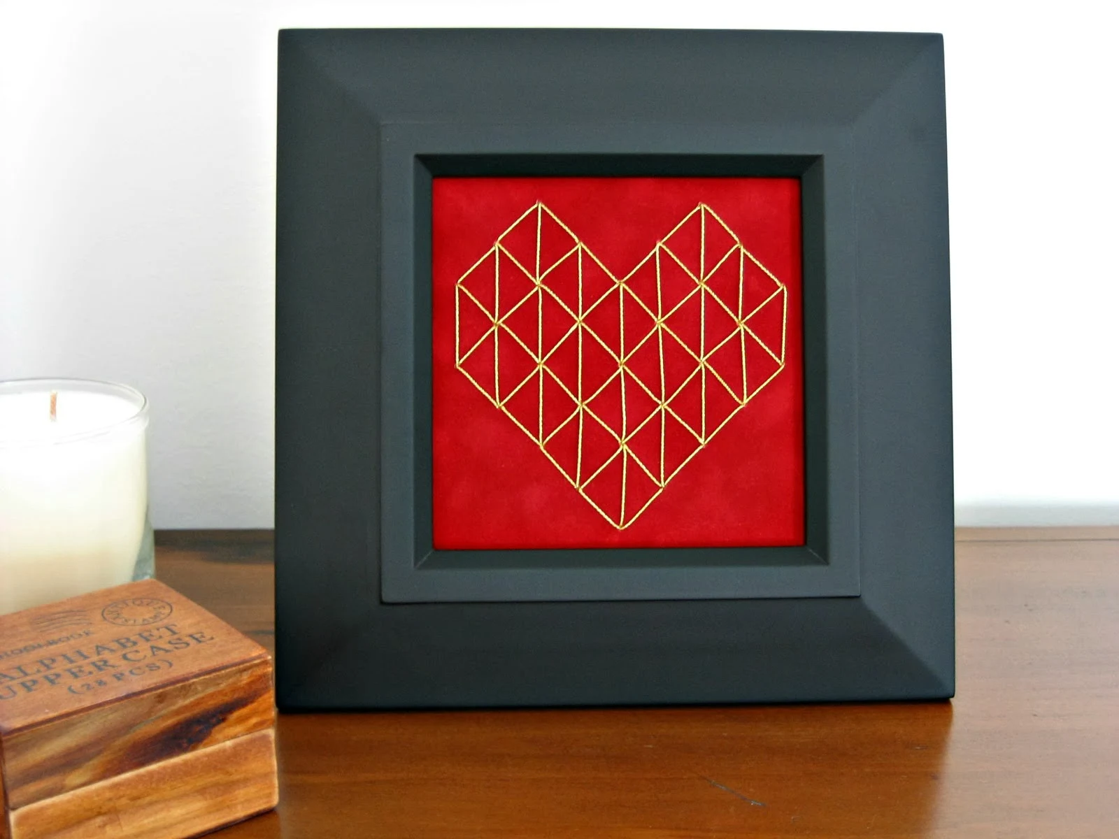 stitched geometric heart on paper in frame