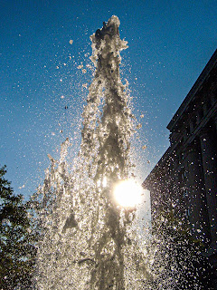 The sun shining through a fountain