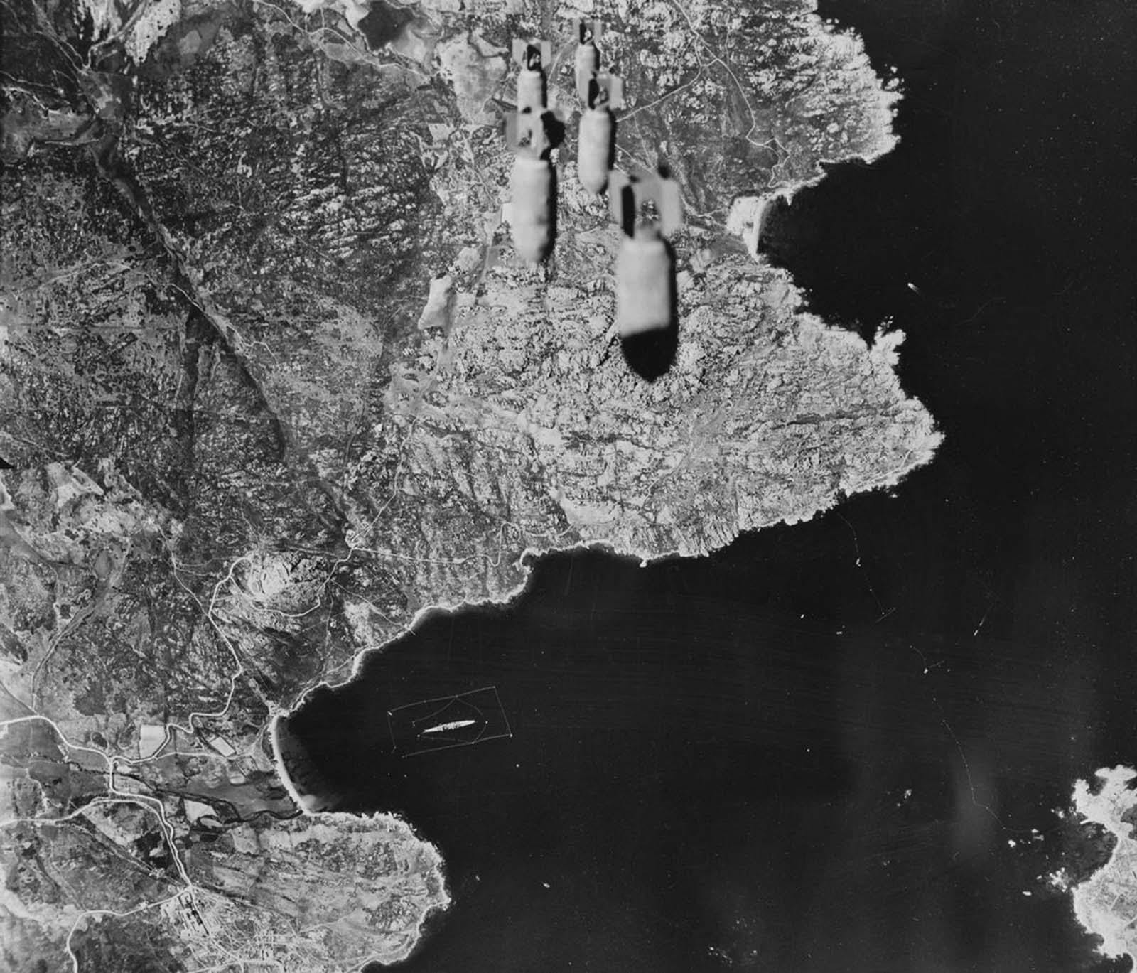 Um trem de bombas cai do avião das forças aéreas do exército dos Estados Unidos em território nas Aleutas mantidas pelos japoneses em 1943.