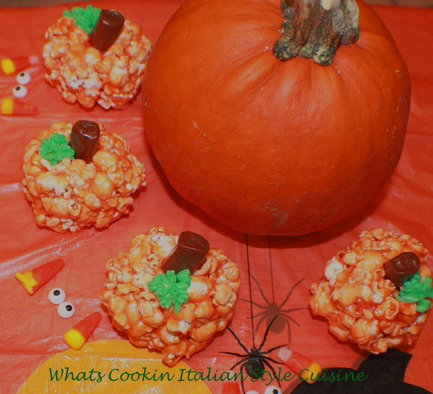 these are easy popcorn balls for Halloween shaped into pumpkin heads rice krispie treats recipe