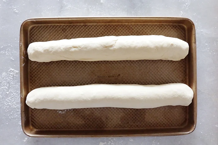 shaped Italian bread dough on sheet pan