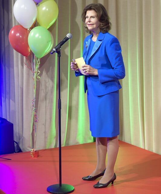 Queen Silvia wore a royal navy tuxedo lapel blazer jacket and navy midi skirt by Georg et Arend. Mourjjan suit. Gold brooch