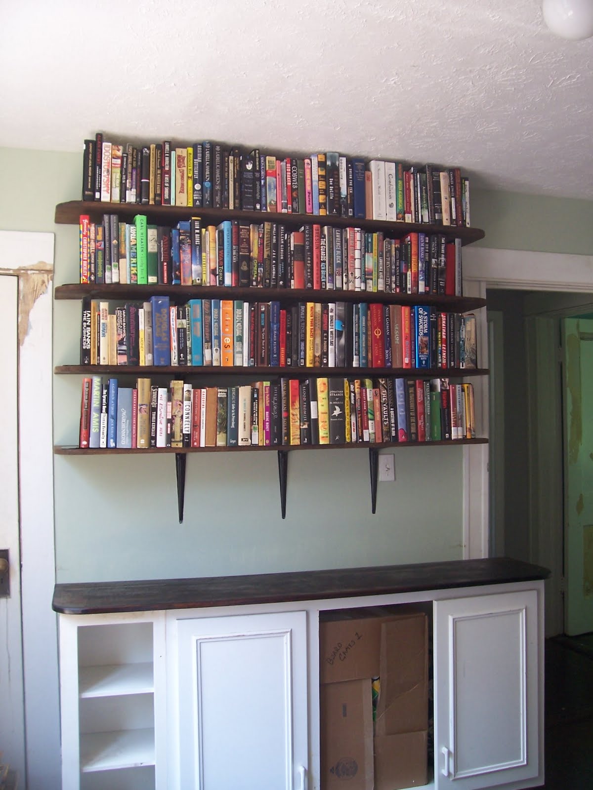 After: Wall o'shelves and cabinet in place]