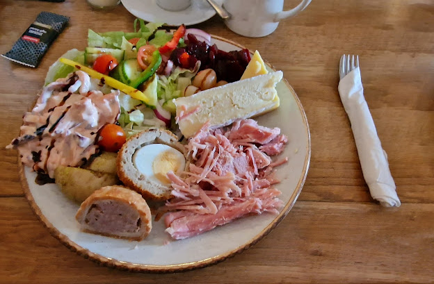 The Potting Shed platter with salad of lettuce, cucumber, tomatoes, onion with dressing. New potatoes. Ham, Cheddar, Brie, Pork Pie, Scotch Egg, freshly made coleslaw and beetroot.