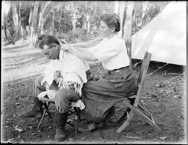 Mrs Charlotte Teale trims Edmund Teale's hair. Geological field camp, Portuguese East Africa. 1911. E.O. Teale photograph collection.