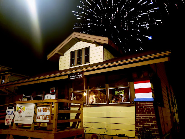 color night-time view of Grafton Illinois coffee antiques shop Lightkeepers Coffee 101 E Main St Sears Vallonia with 4th of July fireworks