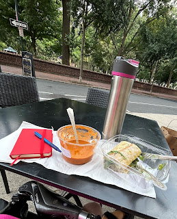 A café table in Philly - with my red journal, plastic containers of tomato soup and a sandwich, and a silver water bottle.