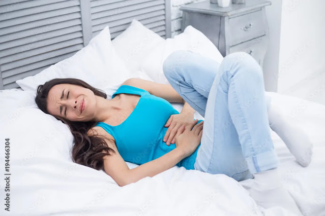 Person lying awake with stomach noises at night