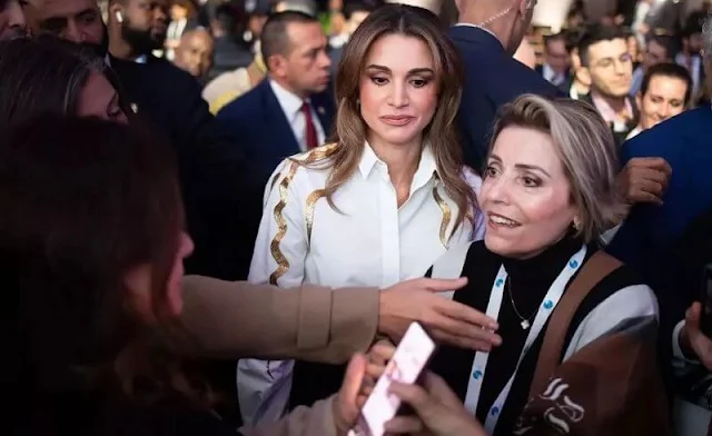 Queen Rania wore a gold metallic lightnings print white shirt blouse, and black trousers. Diamond earrings.