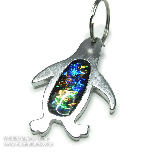 Silver penguin keychain/bottle opener filled with resin and iridescent mylar