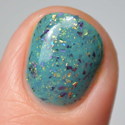 teal nail polish with flakies close up swatch