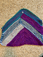 A triangle of knitting in four colors and four patterns