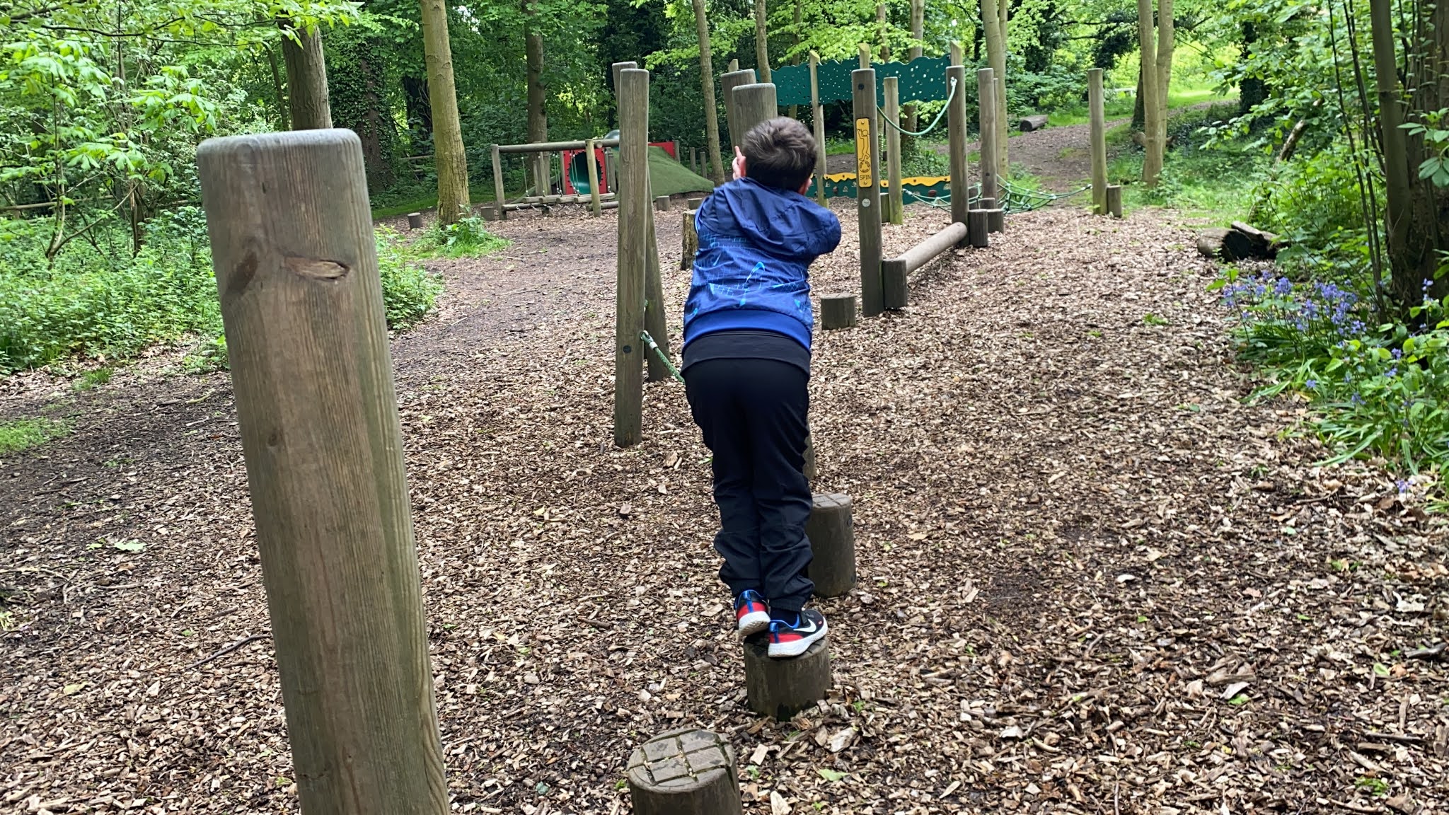 boy playing at a woodland playground