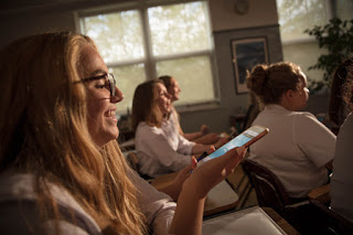 photo of OLSH student using cell phone in class