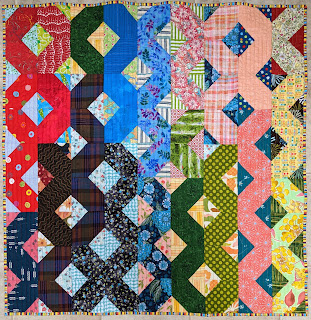 The hatchet block forms ribbons of color down the surface of this small quilt.