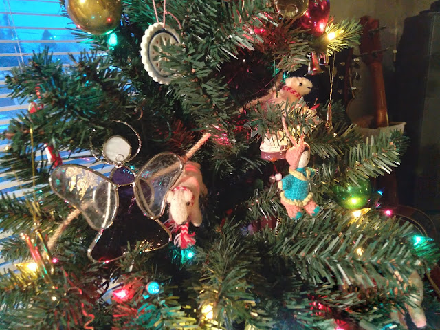 Close view of Christmas tree branches with lights and ornaments