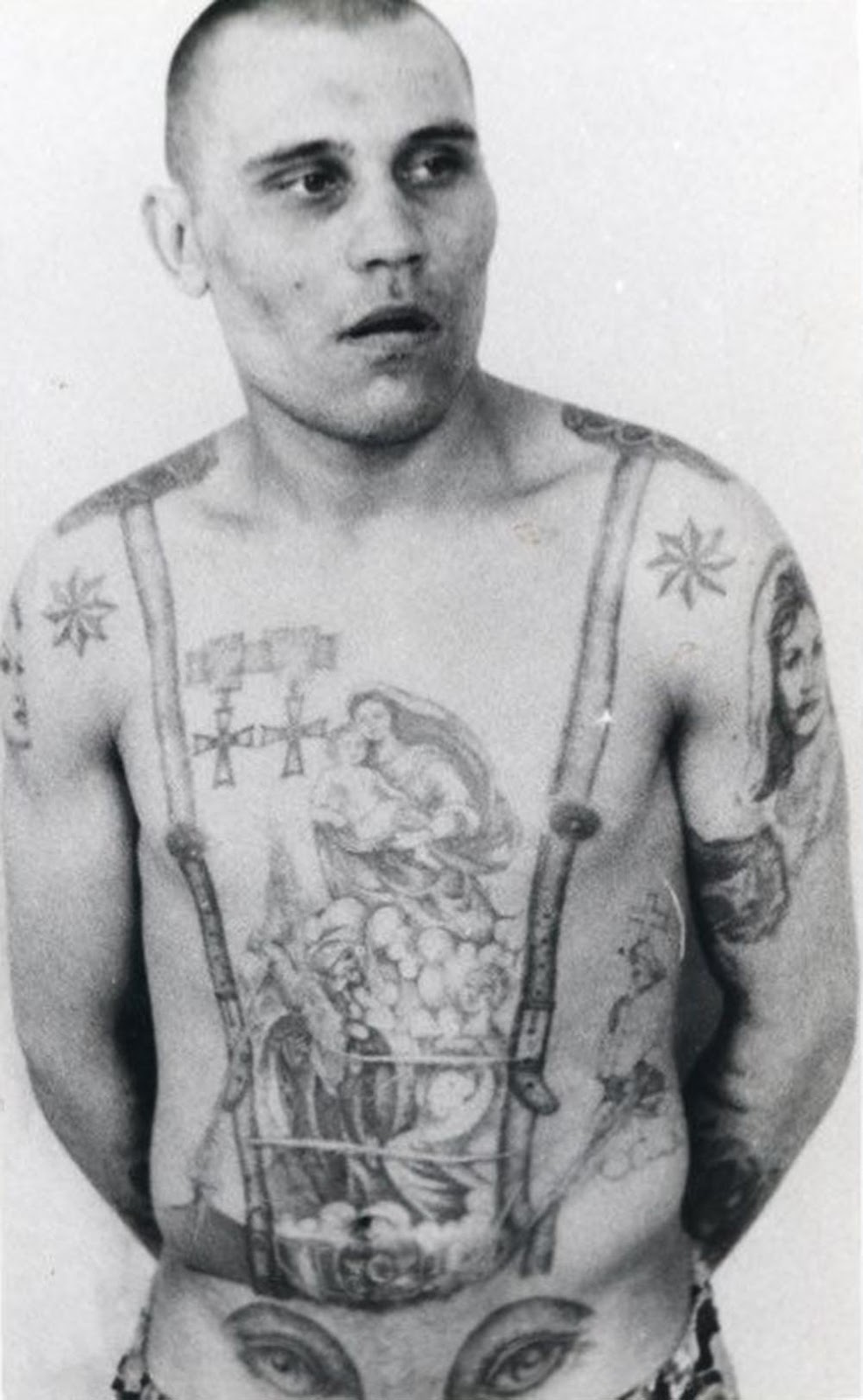 The stars on the shoulders show that this inmate is a criminal authority. The medals are awards that existed before the revolution and, as such, are signs of antagonism and defiance toward the Soviet regime. The eyes on the stomach denote a homosexual (the penis makes the 'nose' of the face).