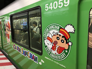 A green Tokyo subway train plastered with pictures of Crayon Shin-Chan to celebrate the 25th anniversary of the anime